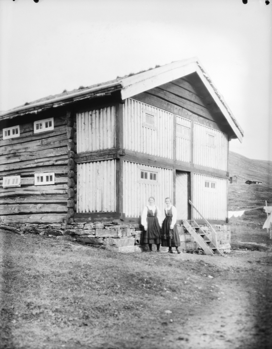 Sjodalen, to kvinner i bunad ved et stabbur eller loft ved Bessheim