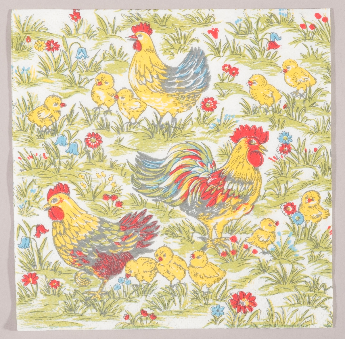 En hane, to høner og mange kyllinger i en eng med røde og blå blomster.