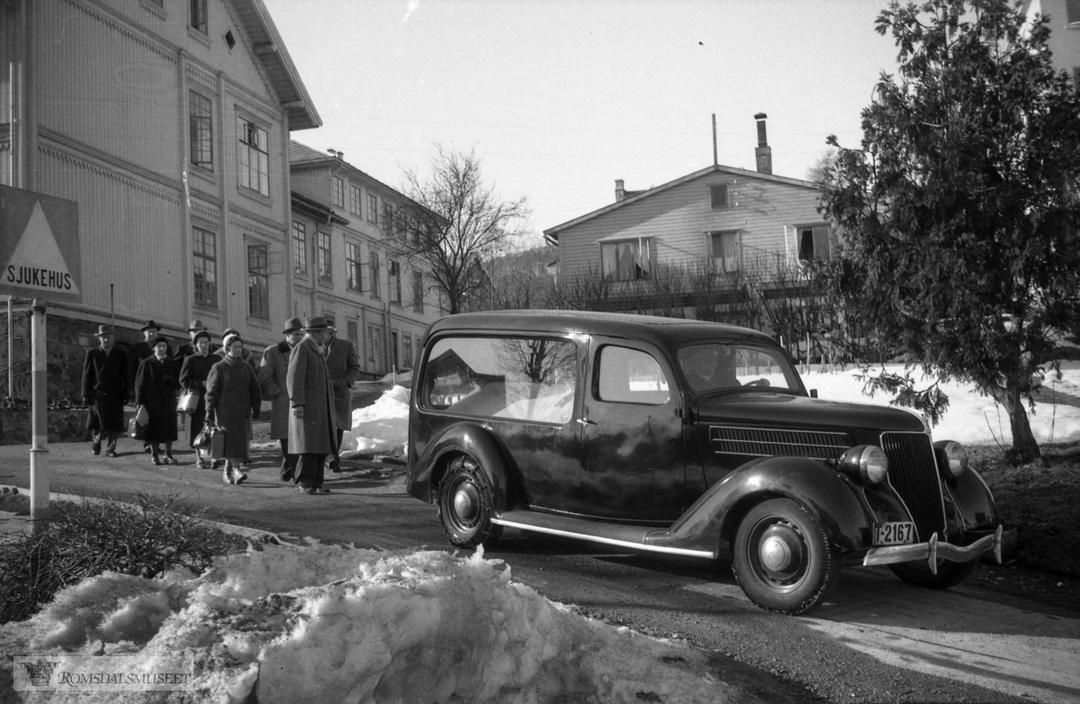 "1958"."Gravferd fru Opstad 21.01.1958?" .Gravferden til Emilie Bjørnerem g.Opstad f.12.09.1887 d.28.03.1958..Begravelsesbilen er en Ford V8 1936 med registreringsnummer T-2167.