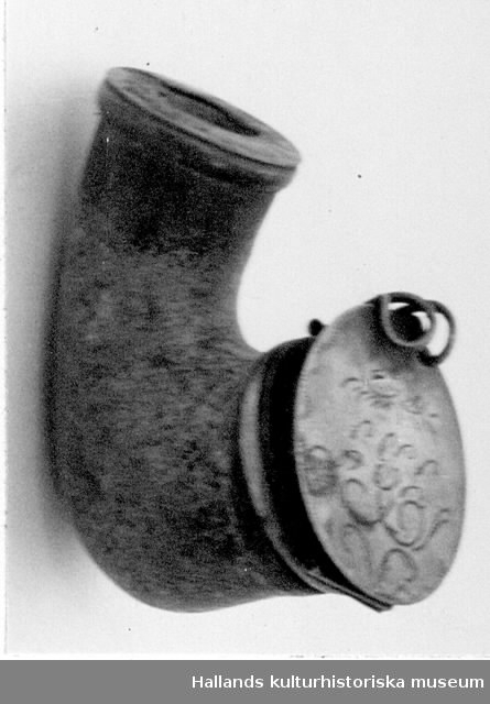 Piphuvud av masurbjörk med ring och fällock på gångjärn. Locket dekorerat med rankor och märkt med initialerna "SBS" (se märkning bild). Stämplar.