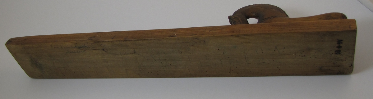 Rektangulær avlang plankeformet gjenstand med håndtak for glatting og rulling av vasket tøy. Planken er dekorert med karveskurde 6-bladsroser. Håndtaket er formet som en hest.