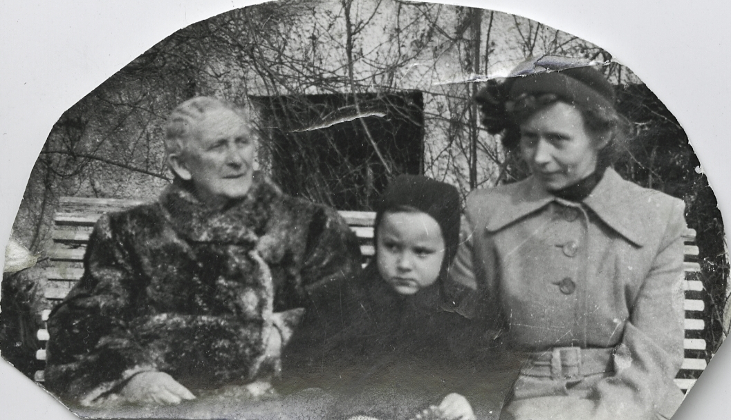 Gruppebilde på en benk i hagen med skipsreder Bertha Torgersen, nevøen Kjell og ukjent kvinne