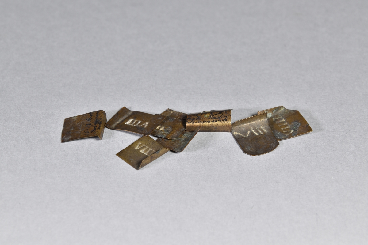 Vikter, 9 st, av mässingsplåt fyrkantiga med inpressade romerska siffror.