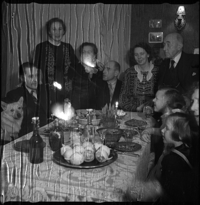 Familien Johannessen samlet for feiring av jul hos Einar Juvvik (født Johannessen). De sitter til bords og går rundt juletreet.