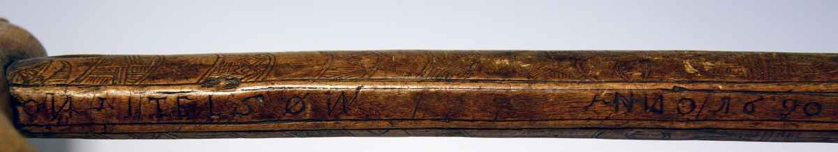 Vandringsstav. Fra protokollen: Udskaaret vandringsstav av træ med paasat haandtak og stor jernpig, ellipseformet snit, paa den ene side merket: Jon Ketelsøn Anno 1690.