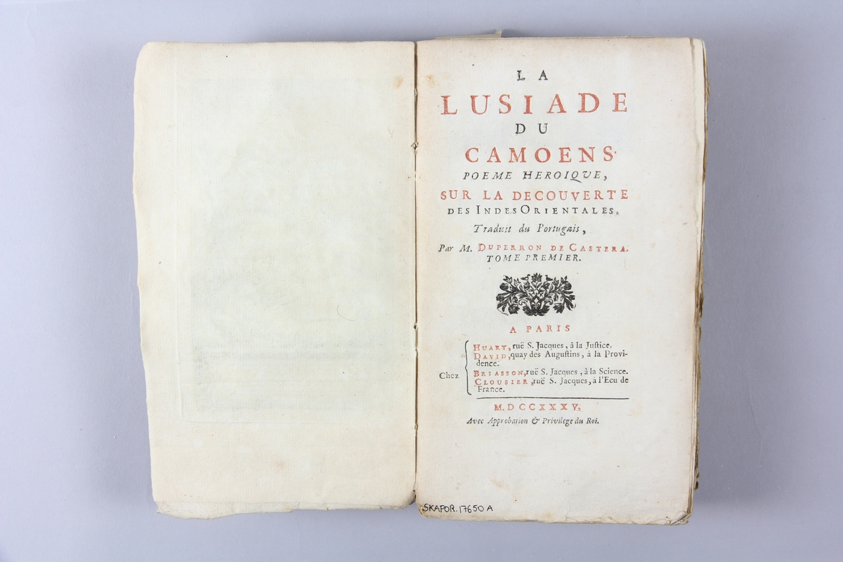 Bok, häftad, "La Lusiade de Camoens", del 1, tryckt 1735 i Paris.
Pärm av marmorerat papper, oskuret snitt.  Blekt rygg med  pappersetikett med volymens titel och samlingsnummer. Illustrationer i koppartryck.