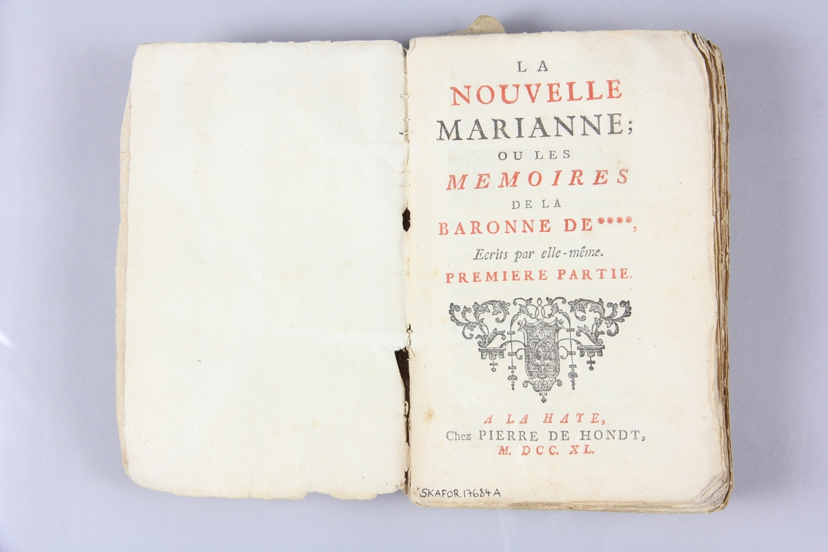 Bok, häftad, "La nouvelle Marianne ou les mémoires de la baronne de ****", del 1,2,3,4, tryckt i Haag 1740.
Pärm av marmorerat papper, oskurna snitt. På ryggen klistrade pappersetiketter med volymens namn och samlingsnummer. Ryggen blekt.