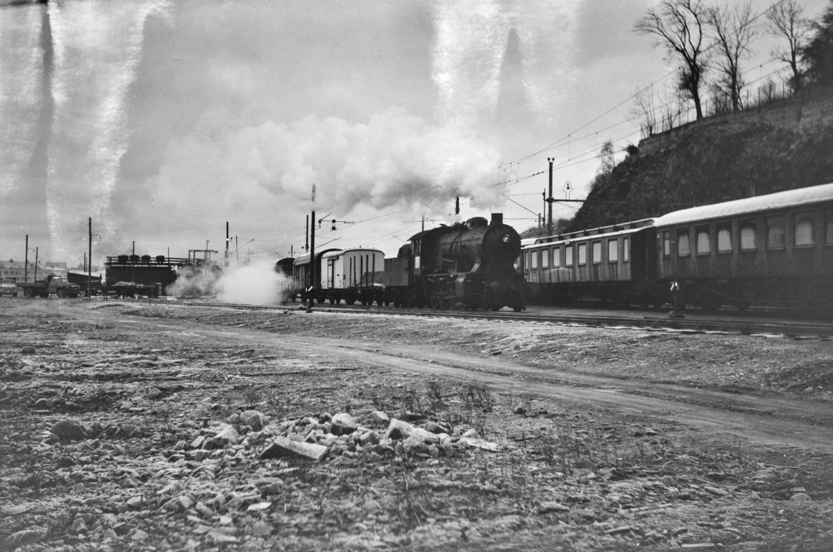 Godstog retning Voss, tog 5500 kjører fra Bergen stasjon. Toget trekkes av damplokomotiv type 33a nr. 300. .