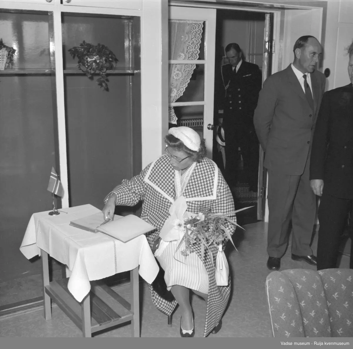 Vestre Jakobselv juli 1959. Kongebesøk på barnehjemmet Vårsol. Prinsesse Astrid signerer besøksprotokoll. Bak til høyre står ordfører Henry Karlsen.