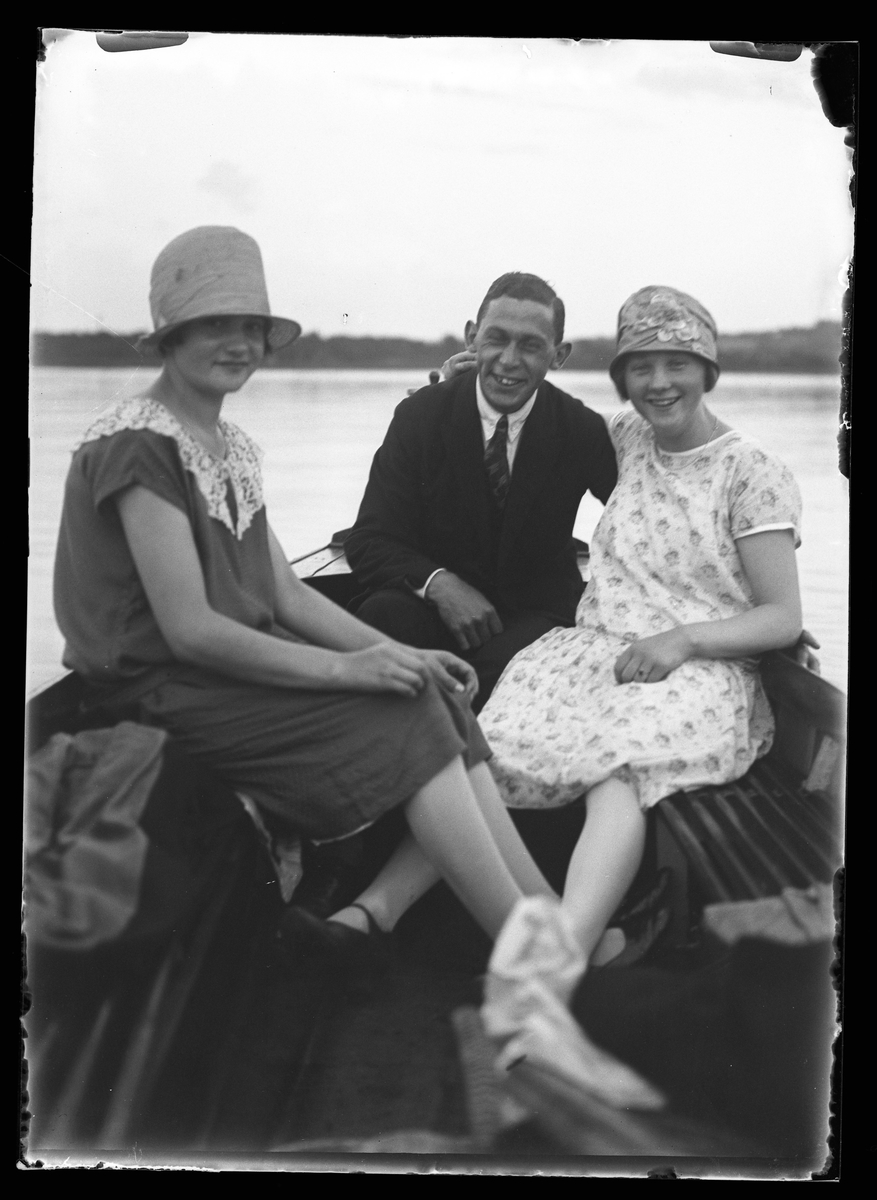 Alice, Hugo Larsson och Märta (troligen Märta Karlsson, senare gift med Hugo) sitter i en båt och ler mot kameran.