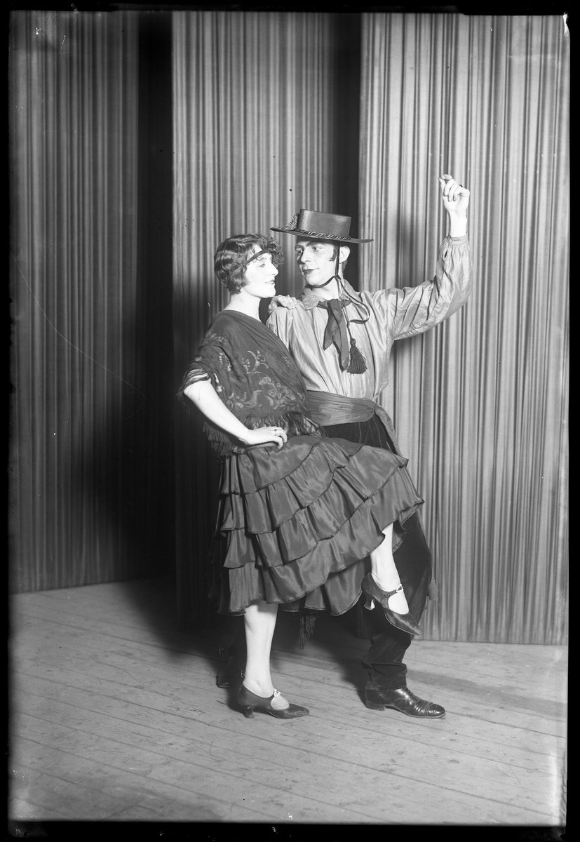 En man och en kvinna poserar framför kameran i samband med Nyårsrevyn. I fotografens egna anteckningar står det "Nyårsrevyn Tangoparet". Tolkat som att kvinnan är Dana Klinge.