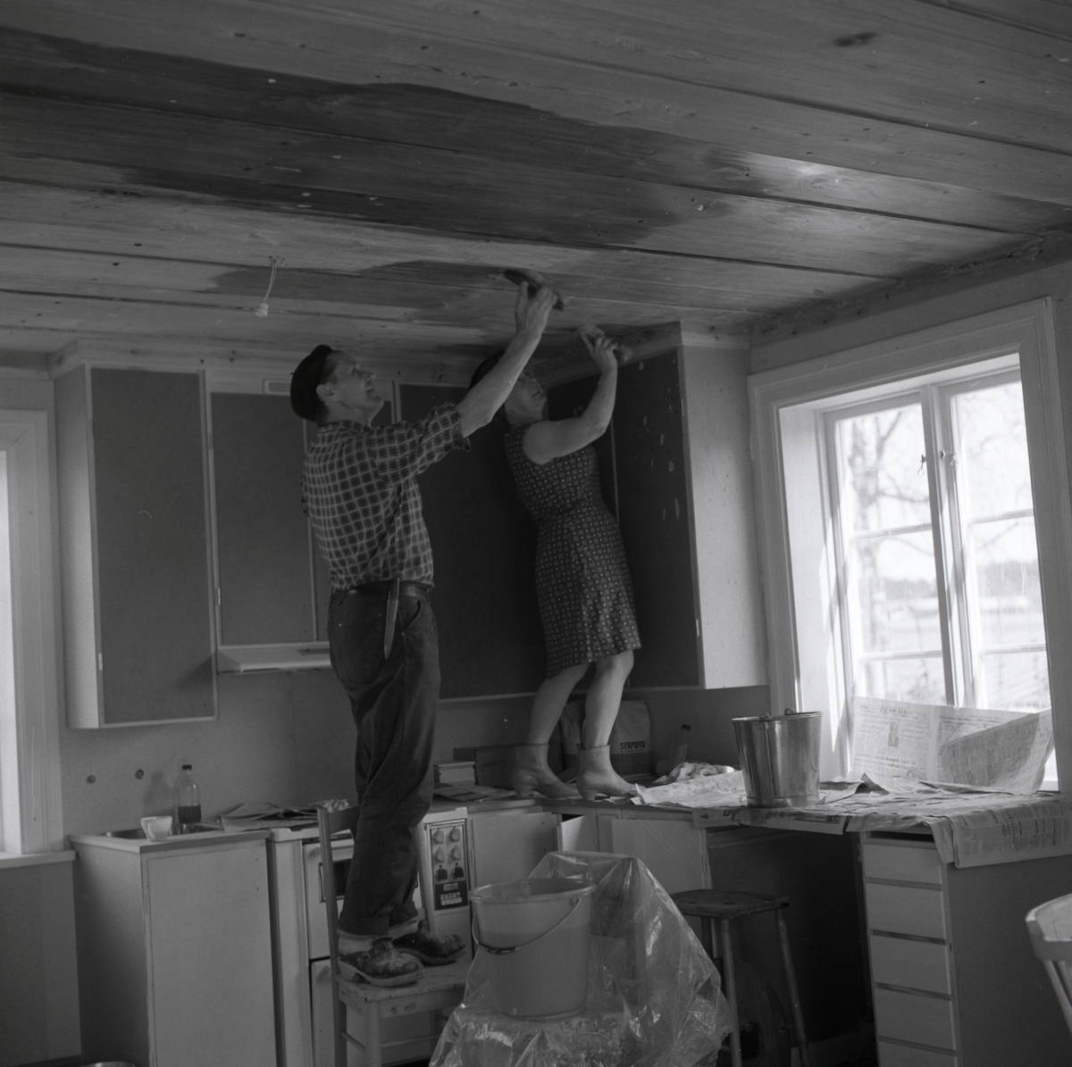Hilding och hans fru skurar taket i köket vid gården Sunnanåker, 1967-1968.
