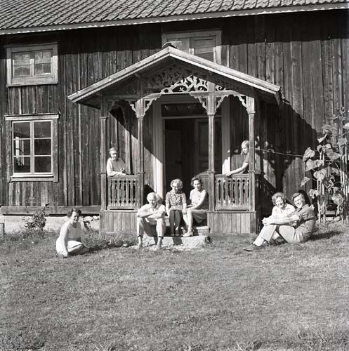 En grupp människor poserar för ett fotografi intill och på en förstukvist i Norrala, 1972.