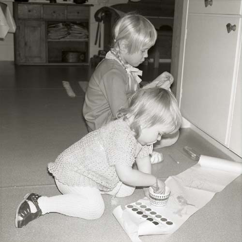 Två barn målar på papper utlagda på golvet, Glössbo 1972.