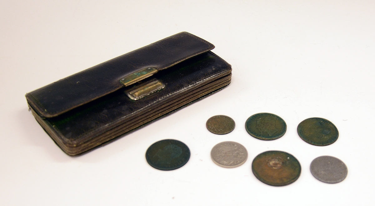 Pengepung av grønt skinn med fem rom + ytterrom med klaff.
Metallklemme over midtrommet. Midtrommet inneholder to italienske, to tyske, en norsk og en fransk mynt.