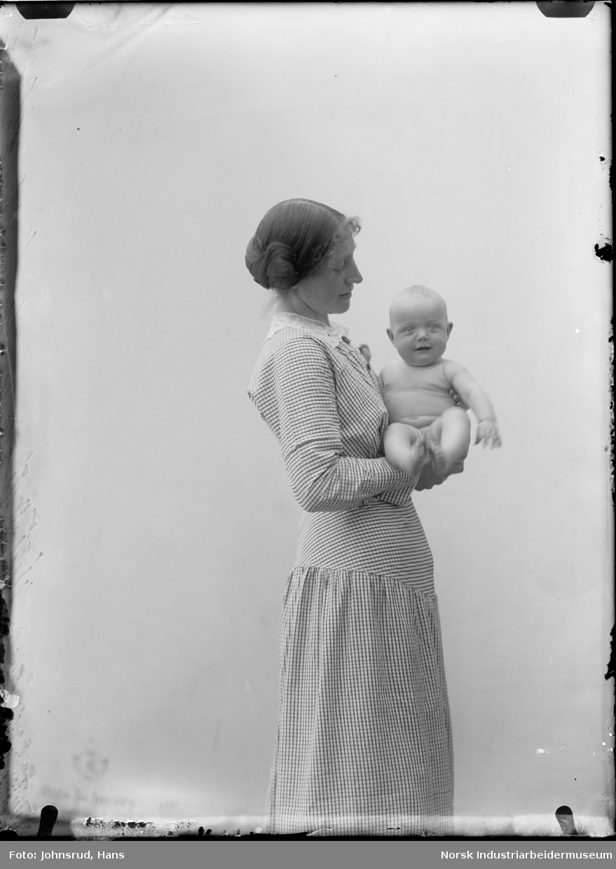 Portrett. Kvinne med baby i armene.