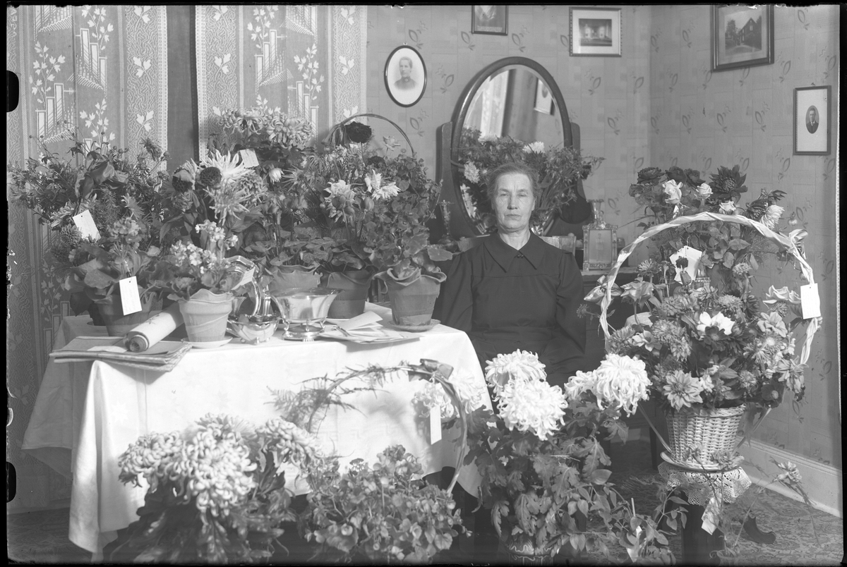 Amanda Johansson fotograferad omgiven av blommor och presenter i samband med sin 70årsdag.
