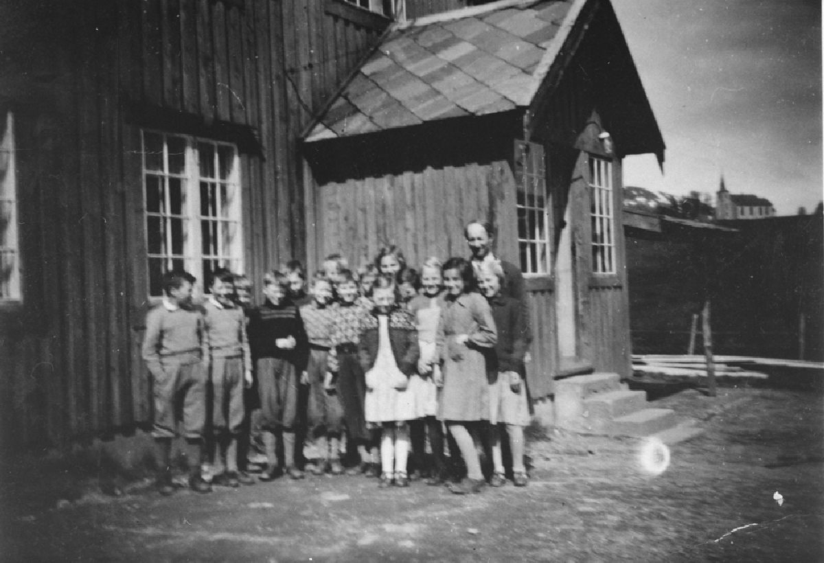 Leirfjord, Bardal. Lærer Kåre Pleym Amundsen med elever utenfor den gamle skolebygningen i Bardal. Personene er ukjente.
Bildet er brukt i Leirfjordkalenderen - november 2005