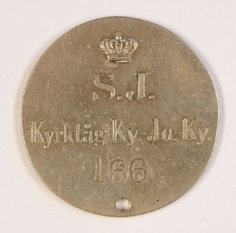 Resepollett av silverfärgad metall.
Polletten har överst en kunglig krona. därunder S.J. På mitten texten: "Kyrktåg Ky.-Ju.-Ky". Underst siffrorna 166.