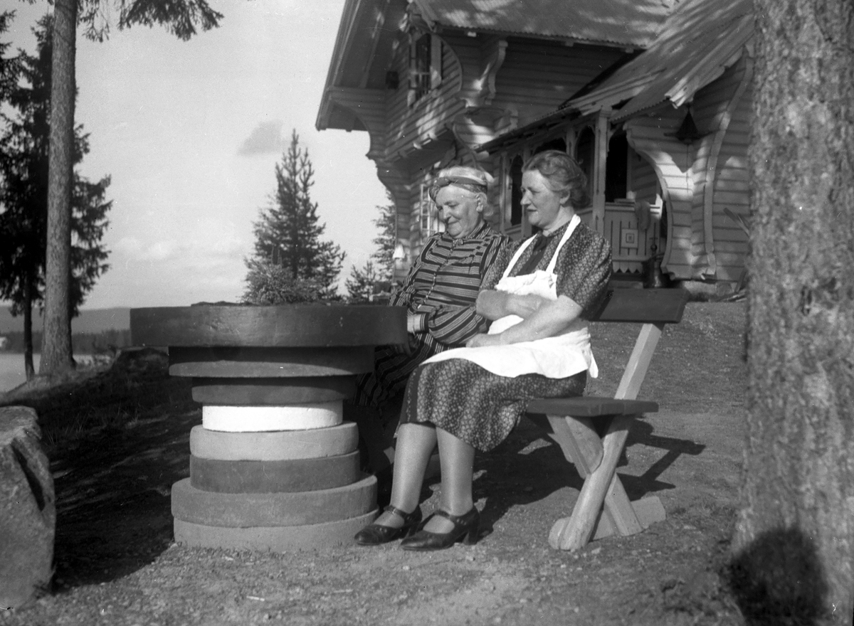 To kvinner sitter ved Vester-Holm.,Lisjøen.