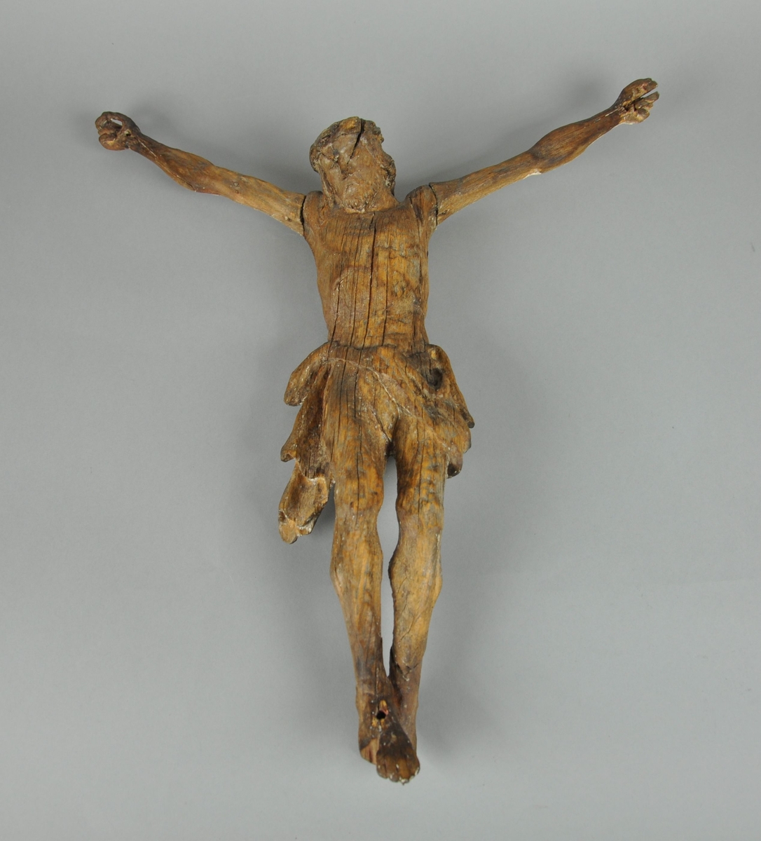 Figur av tre, forestiller Jesus med armene utslått. Figuren hører opprinnelig til en Barokk altertavle. Enkelte sprekker i treverket, spesielt ved mage og torso.