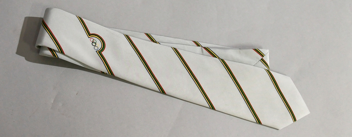 Grått slips med diagnoale striper i de olympiske fargene rødt, gult, grønt, svart og blått, og med de olympiske ringer.