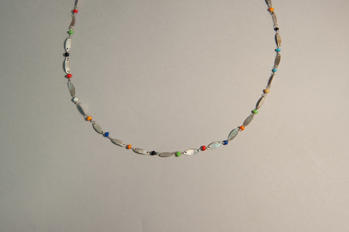 Halsband med ovala metallplattor och glaspärlor i svart, blått, rött, orange, gul, grönt och vitt.