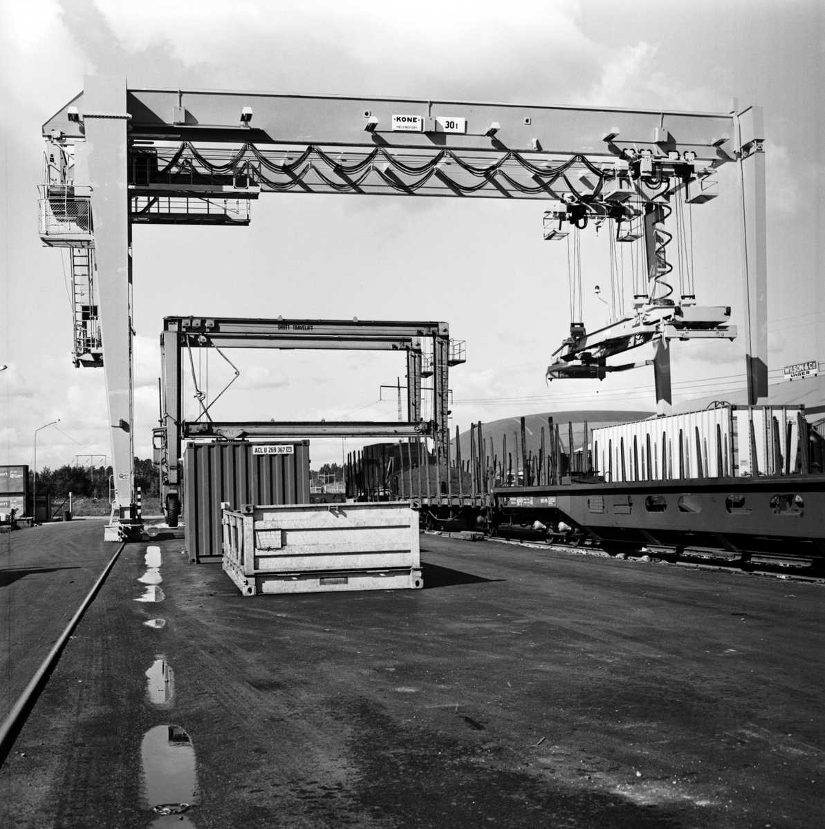 Containertravers som lastar på godsvagnar.