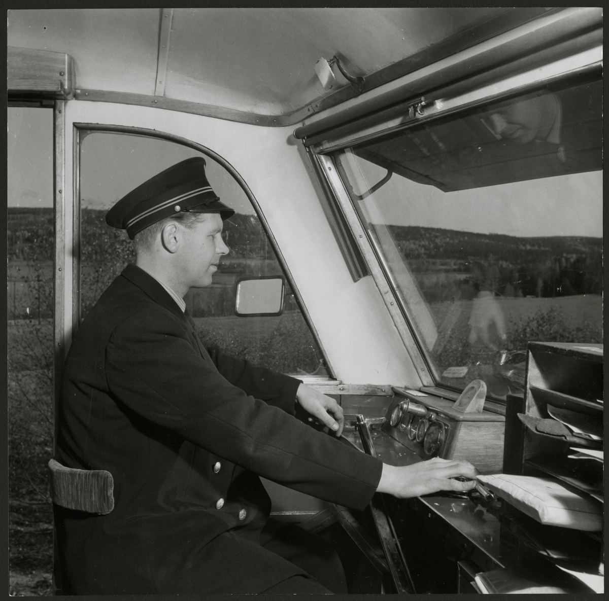 Lokförare på sin arbetsplats i en rälsbuss.