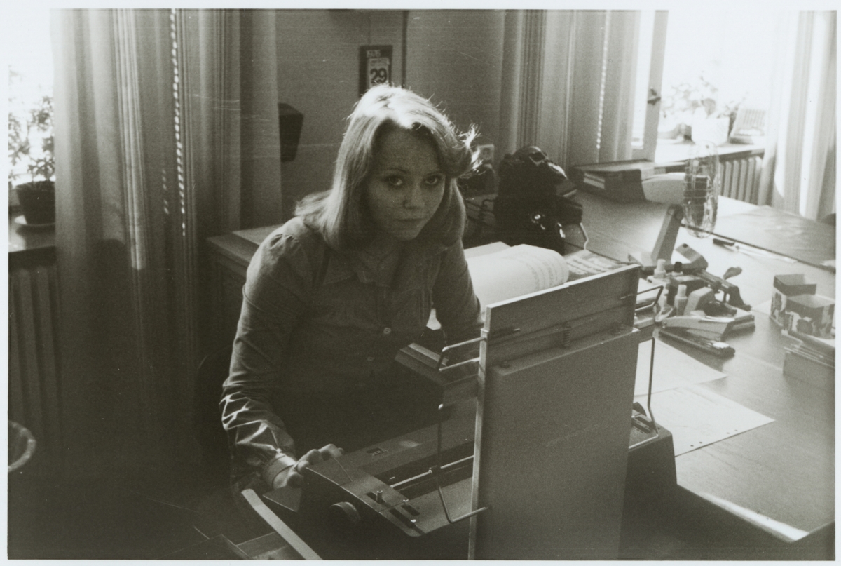Marie Larsson vid en skrivmaskin på ett kontor.