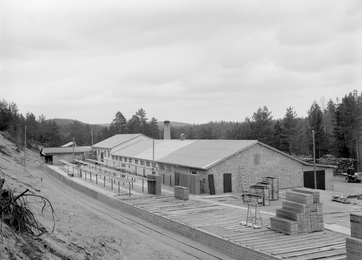 Motiv från Forsnäs AB i Österbymo. Bilden visar företagets anläggning för tillverkning av träullsplattor, som vid sidan av cementhålsten är bolagets stora produkter. Fototillfället dateras varligt till omkring 1950.