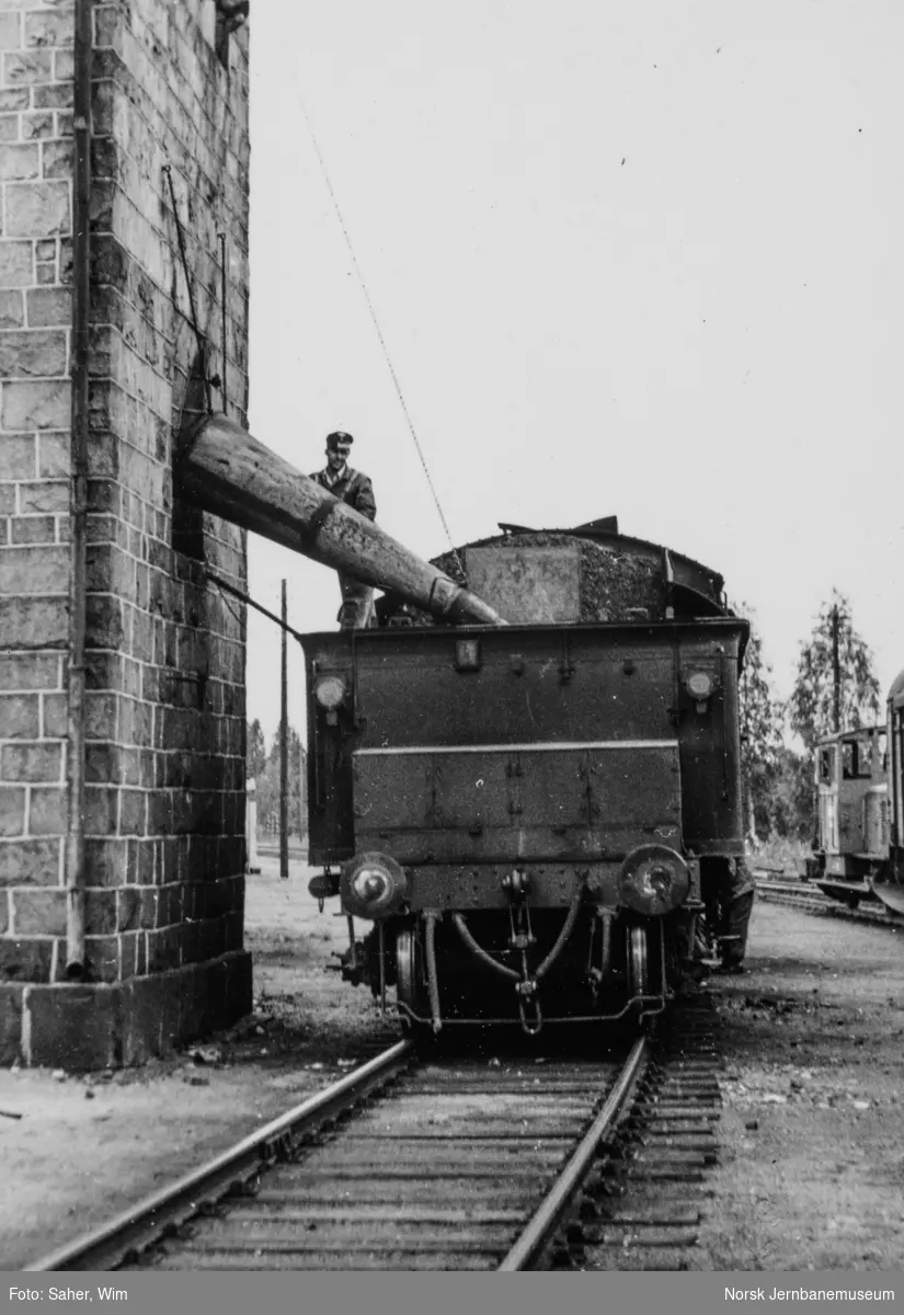 Damplokomotiv type 26a nr. 215 ved vanntårnet på Elverum stasjon. Bak til høyre skiftetraktor Skd 214 nr. 90.