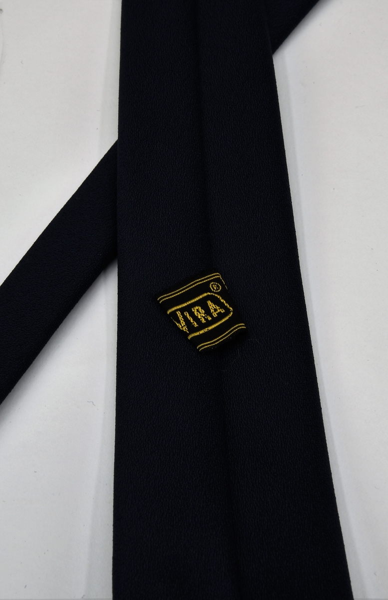 En mörkblå slips med märkning fastsytt på baksidan.