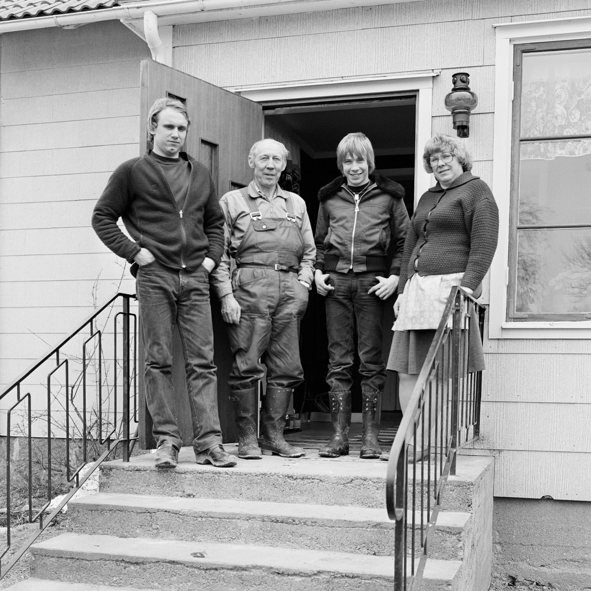 Grupporträtt- lantbrukarna Bertil och Mary Widblad, sonen Krister och avbytaren i ladugårdsarbetet, Mossbo, Tierps socken, Uppland 1981 - 1982