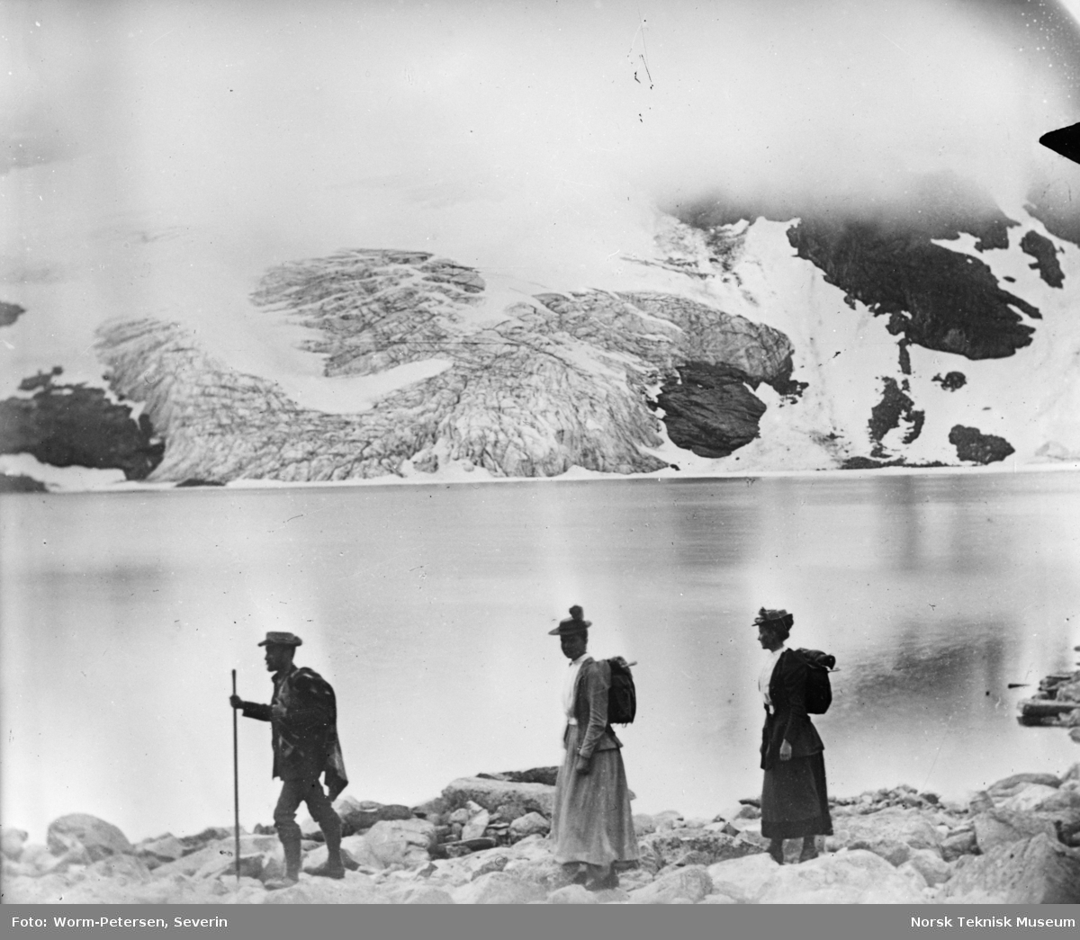 Fire fjellvandrere ved et vann, Jotunheimen