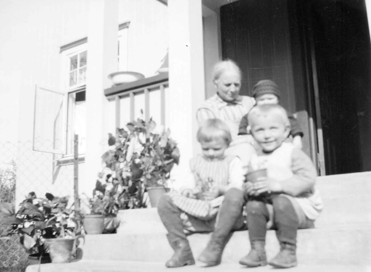 Agnethe Jørstad med 3 barnebarn på trappa på Jørstad Søgarden.