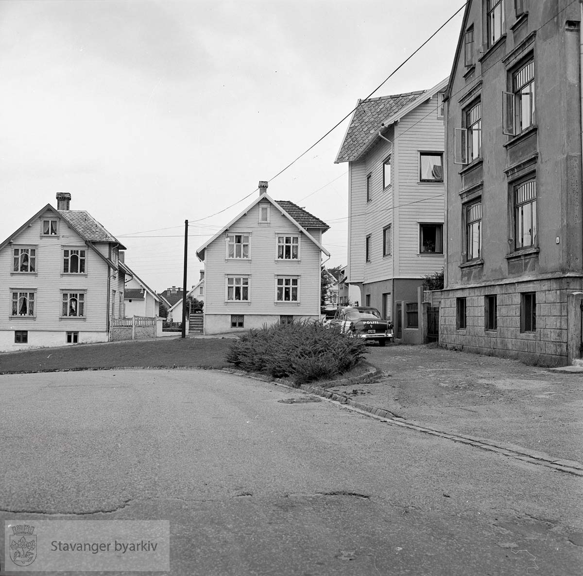 Fra venstre: Øvre Suldalsgate 9, 7, Høgsfjordgata 11 og 9 (murhuset nærmest). En politibil står parkert i gata.