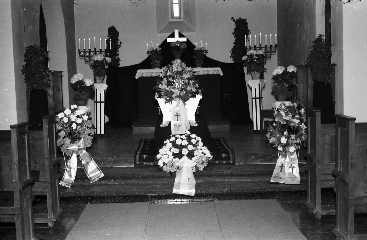 Tre bilder fra en begravelse. Bildene er tatt inne i kirke eller gravkapell, ukjent hvor. På det første bildet er tre uidentifiserte personer samlet ved kista. De to øvrige viser kiste og kranser.