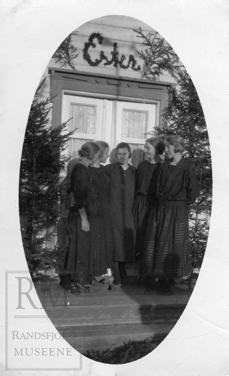 5 jenter står samlet foran dør. Inngangspartiet er pyntet med gran og over døren står det "Ester"