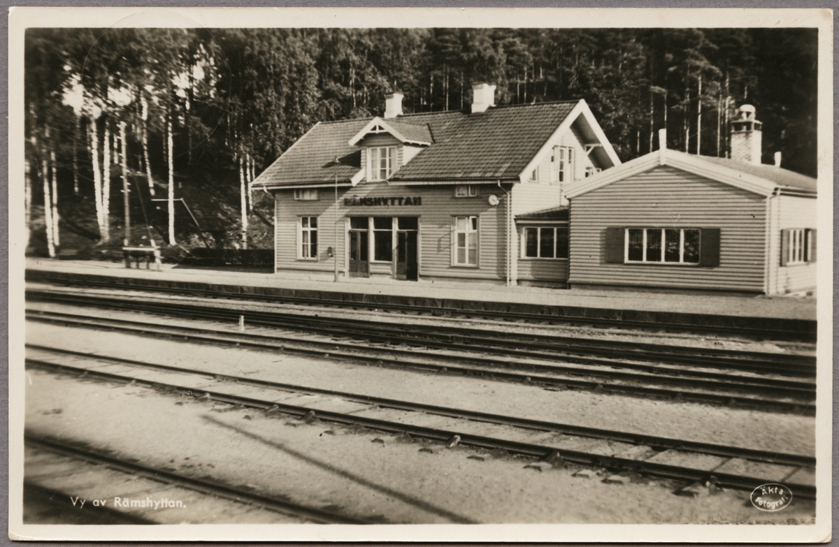 Spårsida av station och stationshus med del av bangård i bild.