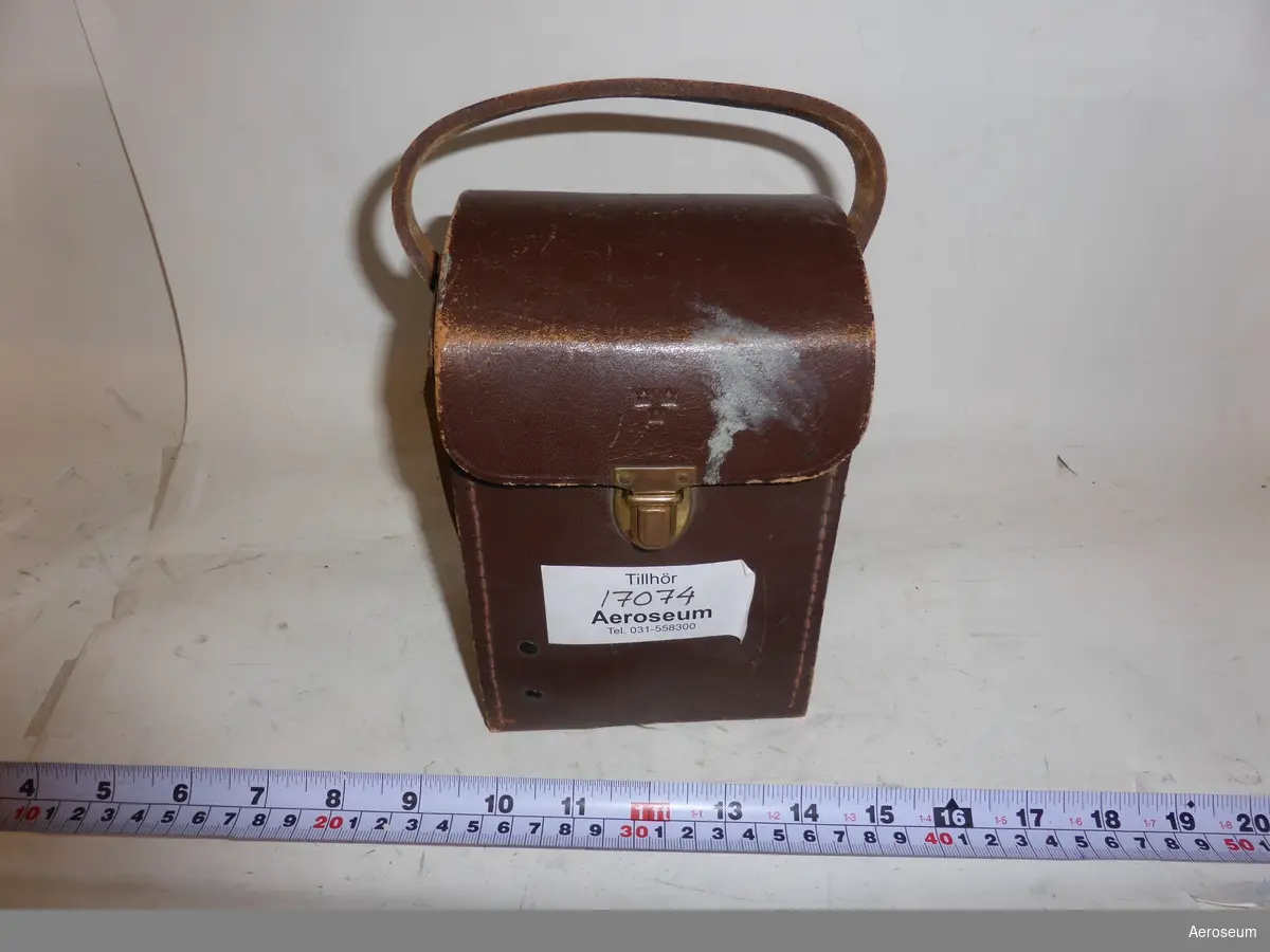 En Kontrollbox i brun läderväska, tillsammans med 2 mättabeller. Till för RA 800. I väskans läder är Tre kronor inpressat och i kontrollboxen sitter det fast en grå sladd.