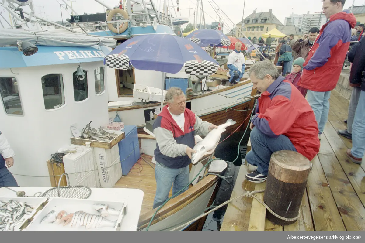 Oslo: Havna. Diverse stemningsbilder. Fiskeskipper Jan Johannesen (t.v.) ombord på "Pelikan" selger fisk til Harald Kristoffersen. 17. mai 1996