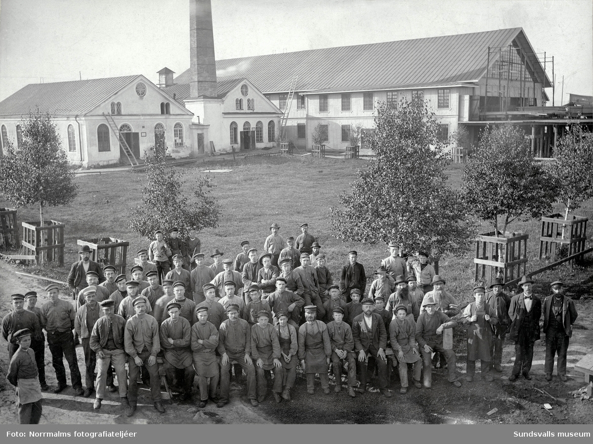 Maskinhuset vid Fagerviks sågverk med förmän och arbetare i förgrunden.