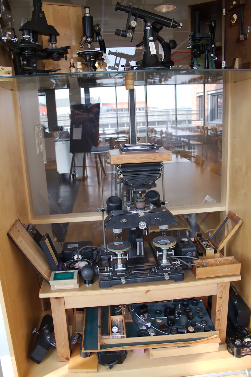 Sammenligningsmikroskop i mange deler. Mikroskopet har fotoenhet, lysmåler og belysningkilde samt ekstra bro med okularholder og objektivholdere med speil.