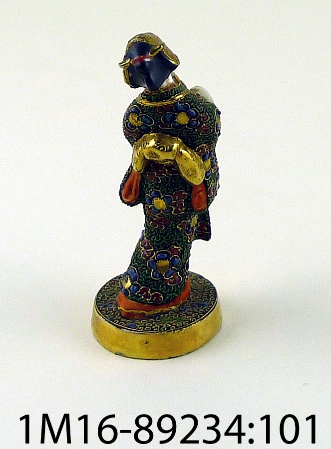 Figurin föreställande japansk kvinna bärande på korg. Mycket detaljerad målad dekor i många kulörer och guld.