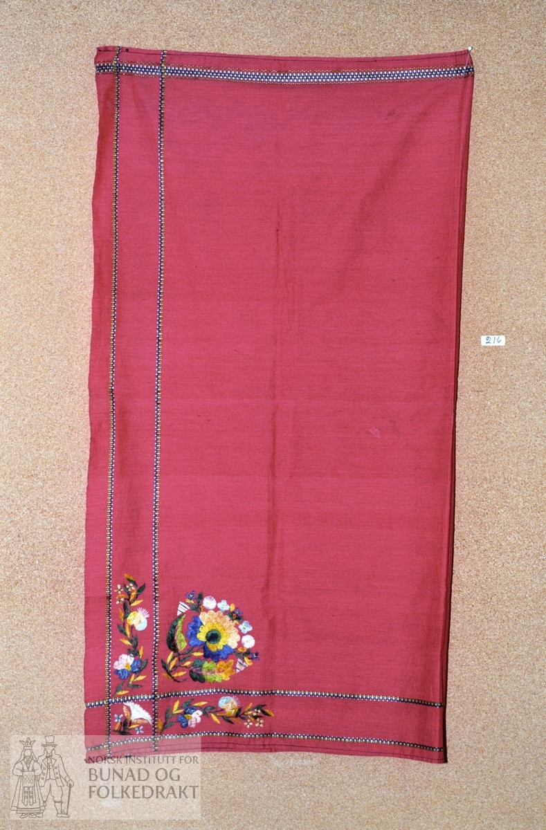 Rosa bomullstørkle med kjerringtenner rundt kanten i silke. Brodert silkerose i to hjørner. Maskinsøm på to sider. Mål:  90 x 95 cm.