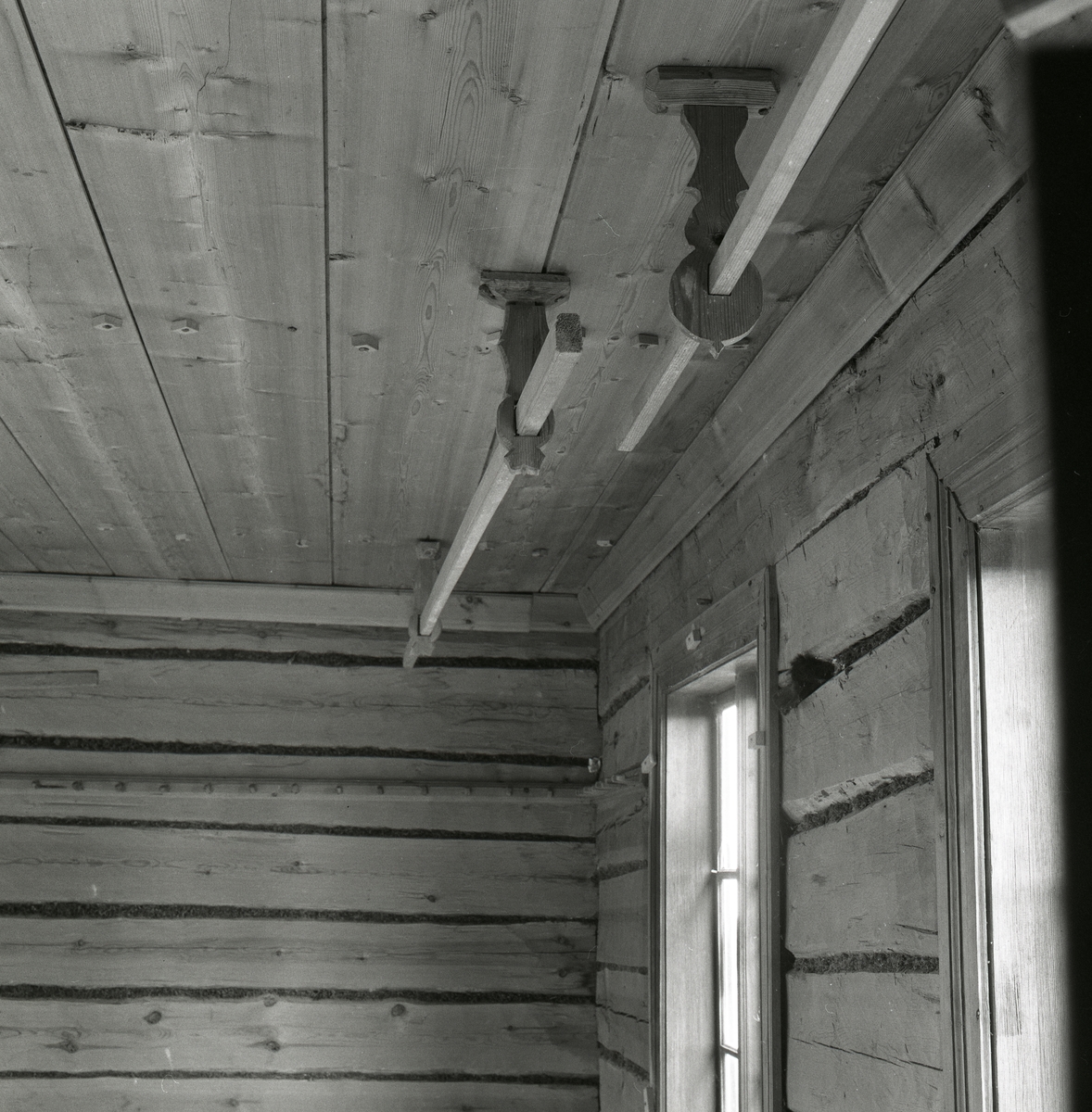 Trägolv, träväggar och träbeslag sitter i taket med träpinnar som går igenom. Det finns också fönsterkarmar. Utegårn 19 augusti 1990.