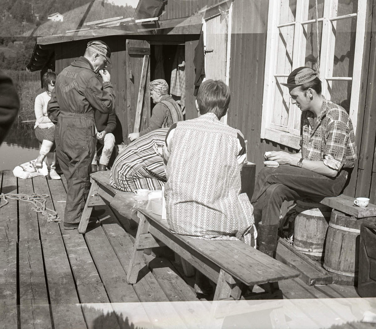 Några personer sitter utanför en byggnad och fikar, Ulvön i Örnsköldsvik, augusti 1970.