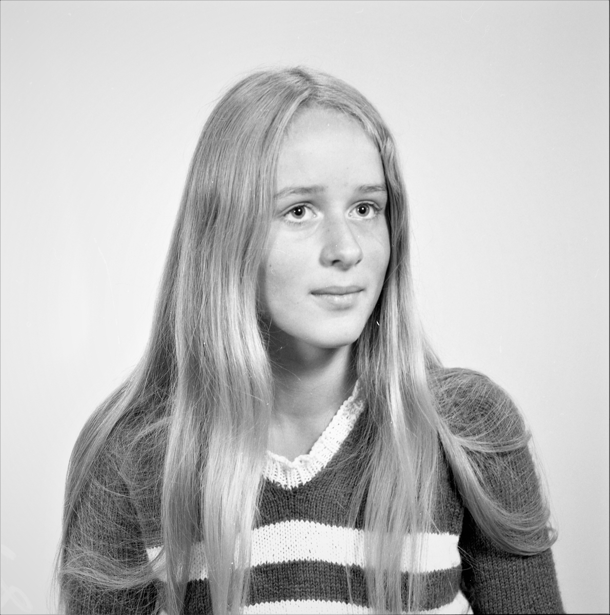 Portrett. Ung kvinne med langt lyst hår i genser med mørke og lys striper. Bestilt av Karin Bull Tornøe. Skånevik