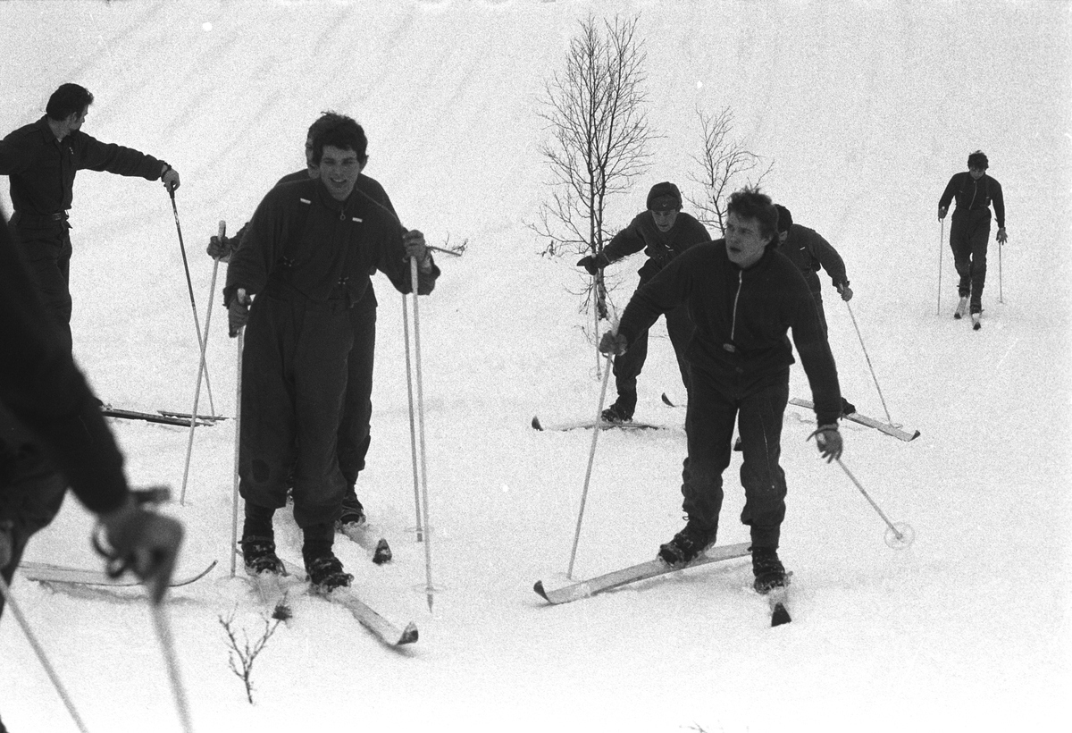 Befalsskoleelever på ski går opp bakke.